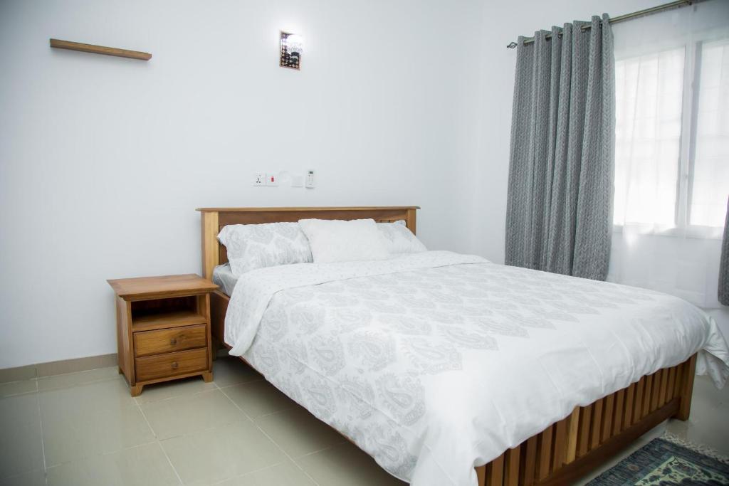 KwabenyanEdenRose home的一间卧室设有一张大床和一个窗户。