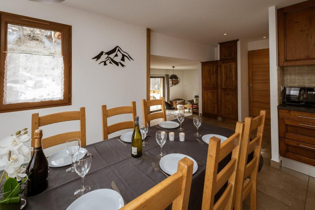 瓦卢瓦尔Chalet Lova的用餐室配有带酒瓶和玻璃杯的桌子