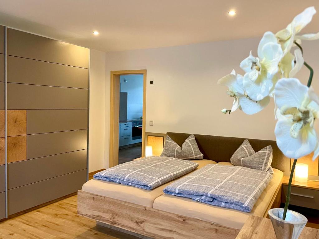 FrankenbergSTADTOASE geräumige Gästewohnungen mit Balkon, Komfort, Modernität und Ruhe, Für Monteure geeignet, Free WiFi的卧室配有一张墙上白色鲜花的床
