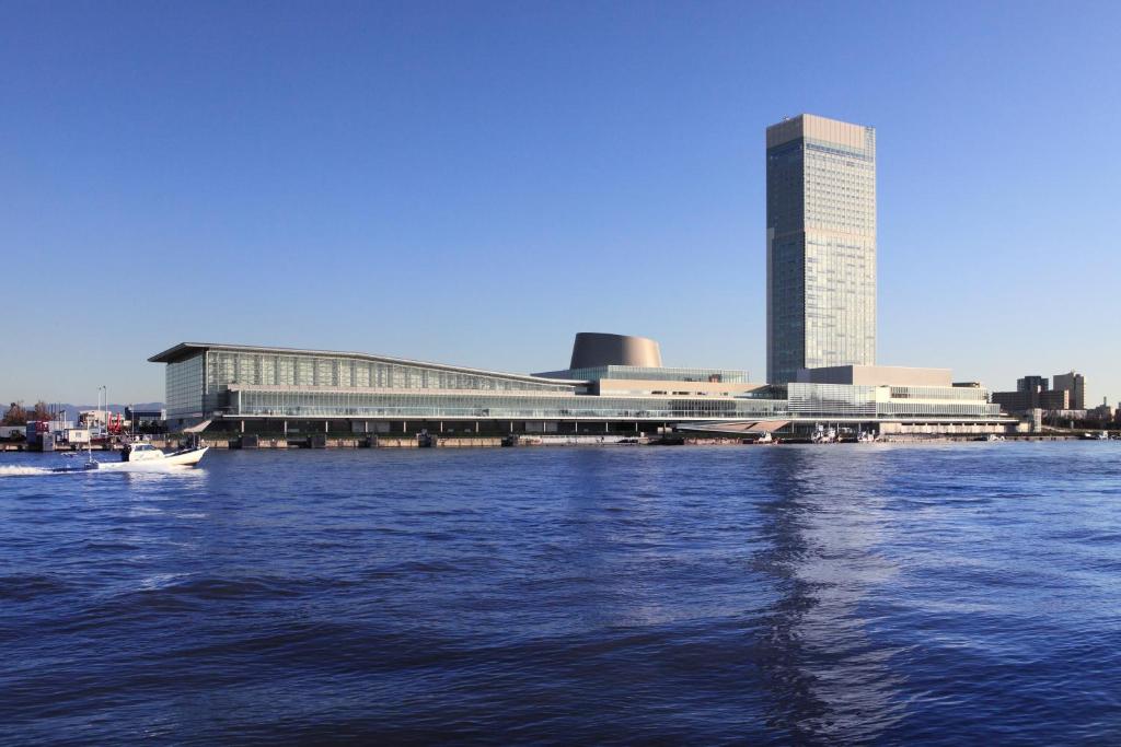 新泻新泻日航酒店的一座大建筑,位于水面上,靠近城市