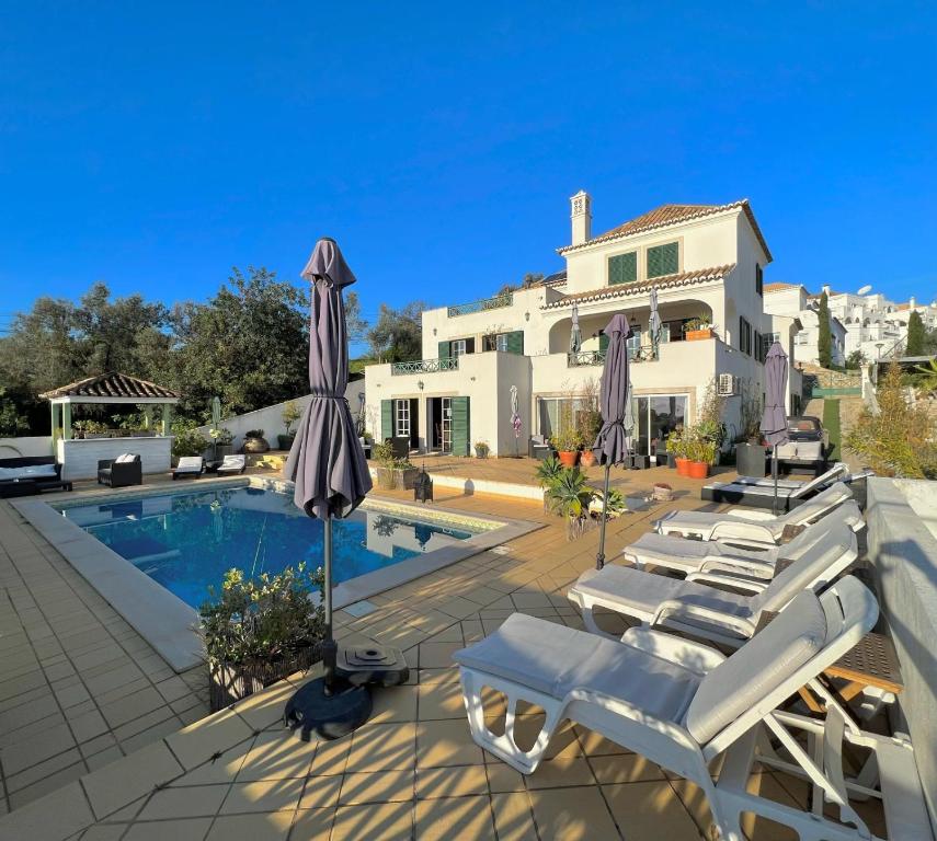塔维拉Tavira Terrace的别墅设有带躺椅和遮阳伞的游泳池