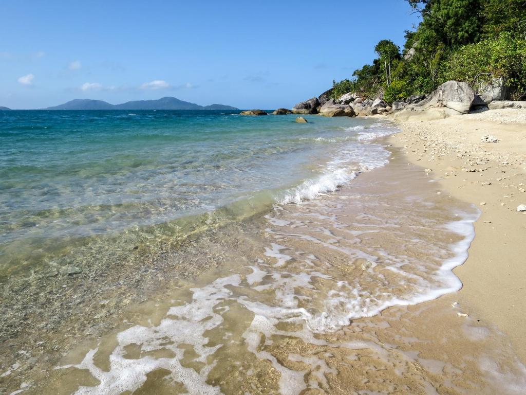 米申海滩密逊迩海滩隐蔽度假村的海滩以海洋和山脉为背景