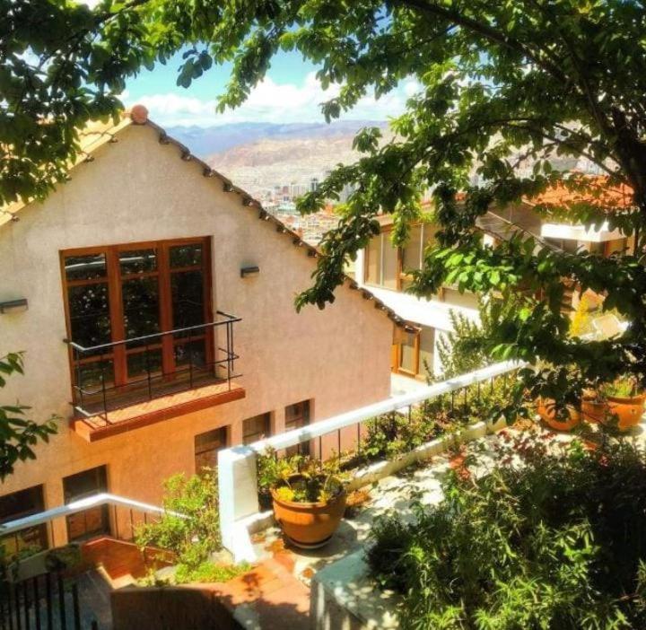 拉巴斯Villa Florita的带阳台的房屋,前面有植物