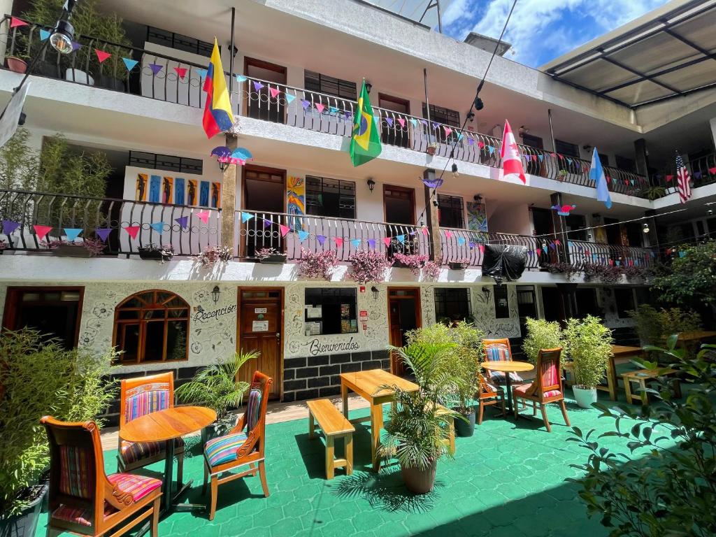 巴尼奥斯El Jardín Escondido Party Hostel的酒店庭院配有桌椅和旗帜