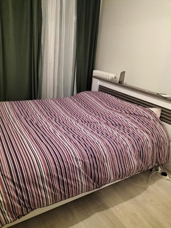 图尔Keva apartment的卧室内的一张带条纹棉被的床