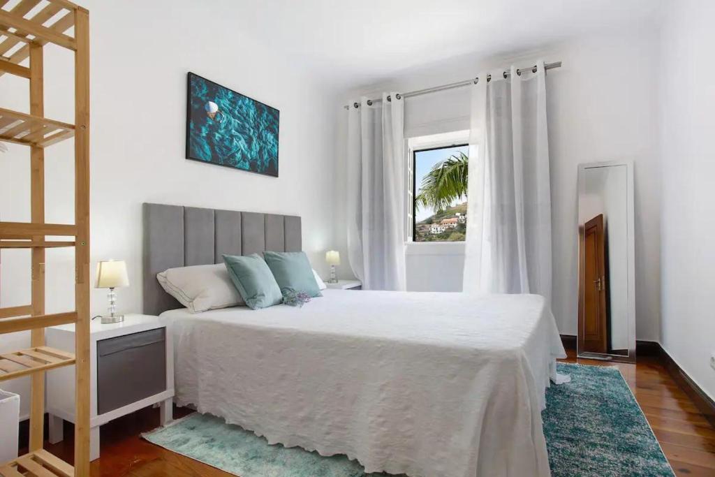 里韦拉布拉瓦Sea La Vie Madeira的白色的卧室设有床和窗户