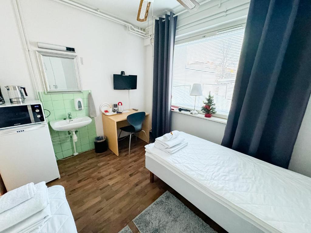 库奥皮奥弘斯坦利玛特卡斯加卡蒂酒店的小房间设有床和水槽
