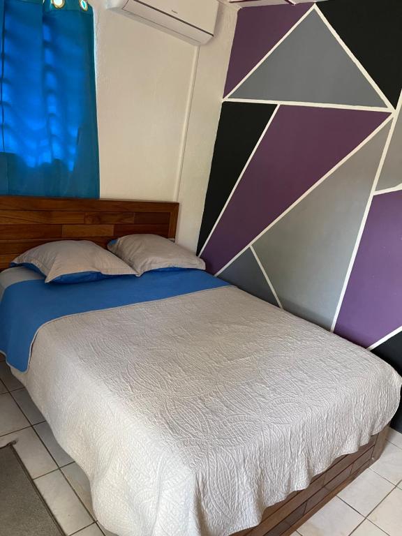 马罗尼河畔圣洛朗Ouest Nelis Lodge的一间卧室配有一张几何墙床