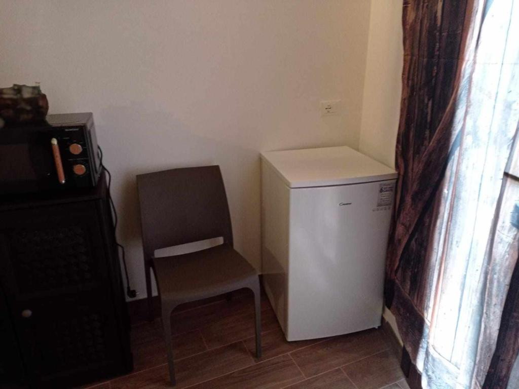法维尼亚纳casa vacanze pupo 2.0的客房内的白色小冰箱和椅子