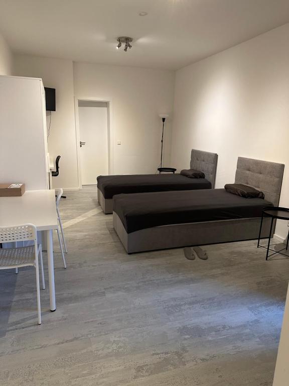 卡塞尔Place to sleep - Kassel: Direkt an der Uni的客房设有两张床、一张桌子和一个黑板