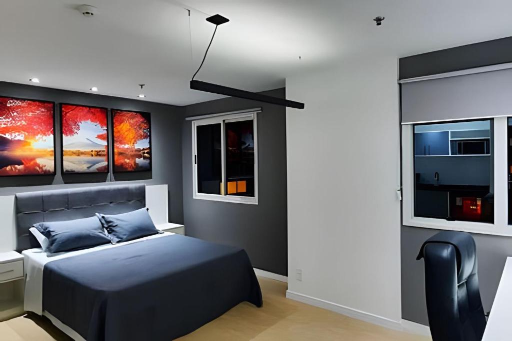 圣保罗Paulista Premium Flat的一间卧室设有一张床和三个窗户。