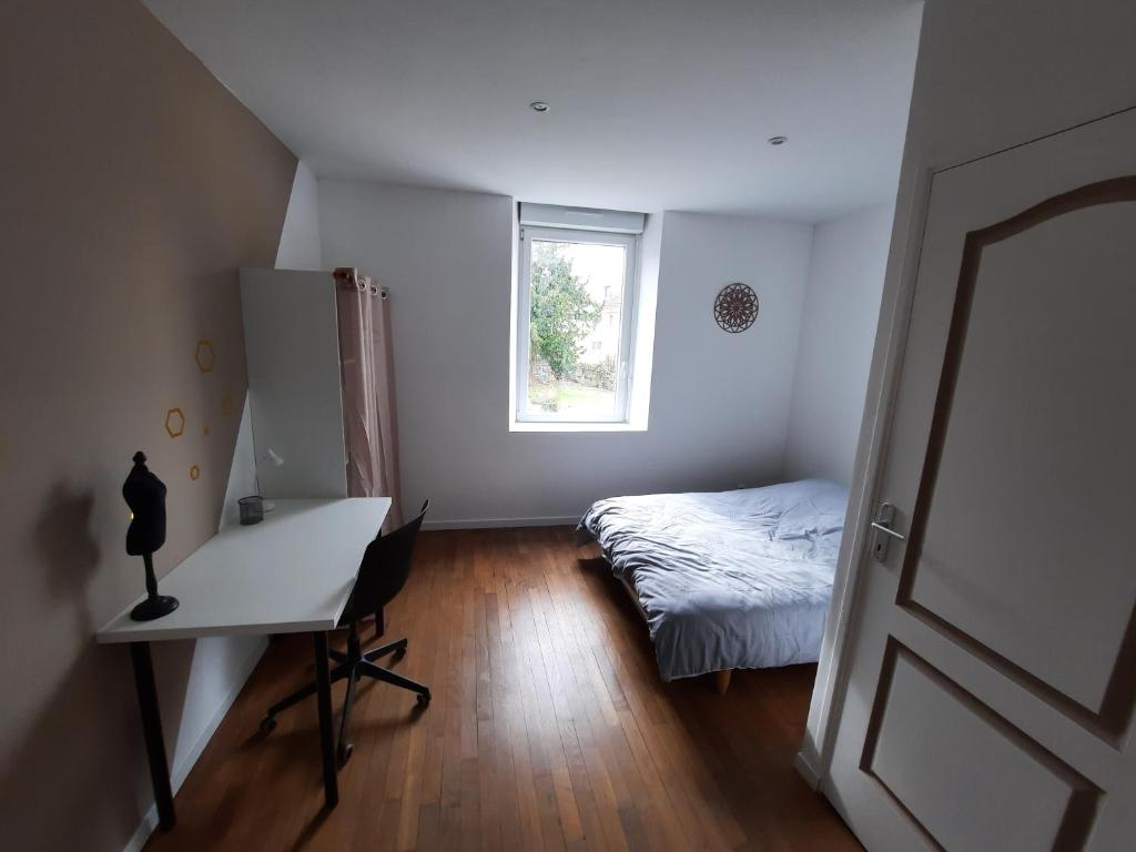 沃苏勒Belle Suite privative centre vesoul的一间卧室配有一张床、一张书桌和一个窗户。