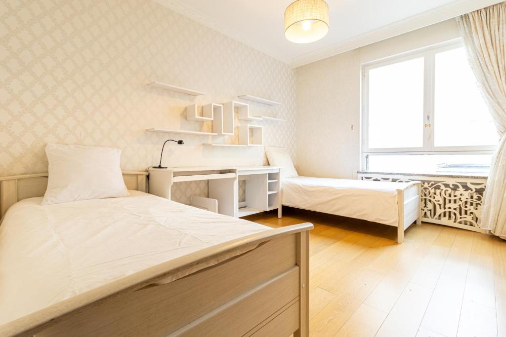 巴黎Spacious flat 120m2 close to Eiffel Tower的一间卧室设有两张床、一张桌子和一个窗口。