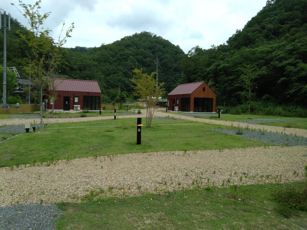 ShōbaraAyu no Sato Park Campsite - Vacation STAY 42166v的一座带谷仓、建筑和田野的公园