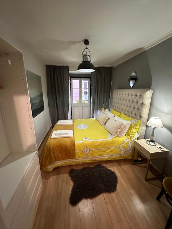 里斯本apartamet in Bairro alto 1的一间卧室配有一张黄色毯子床