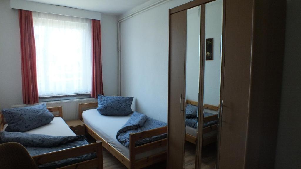 普鲁滕Zwei Bett Zimmer的小房间设有床和镜子