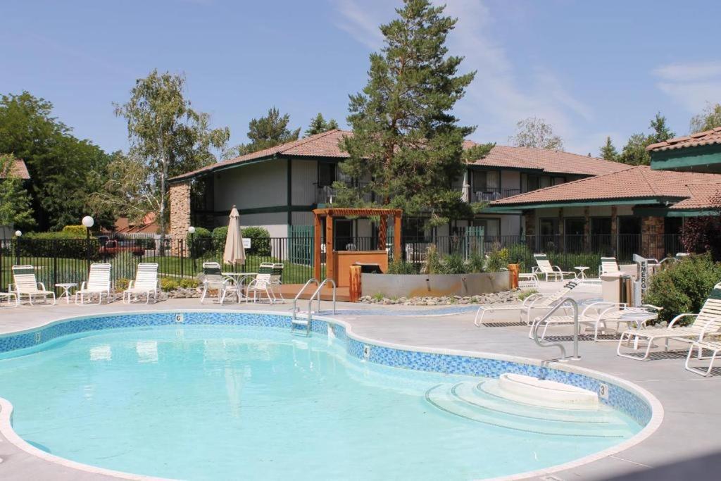 里诺Thunderbird Resort Club的一座带椅子的度假村的游泳池和一座建筑