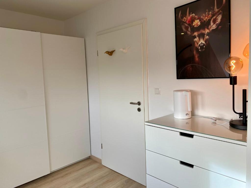 波恩gemütliches Dachgeschoss的白色的厨房,配有白色的橱柜和门