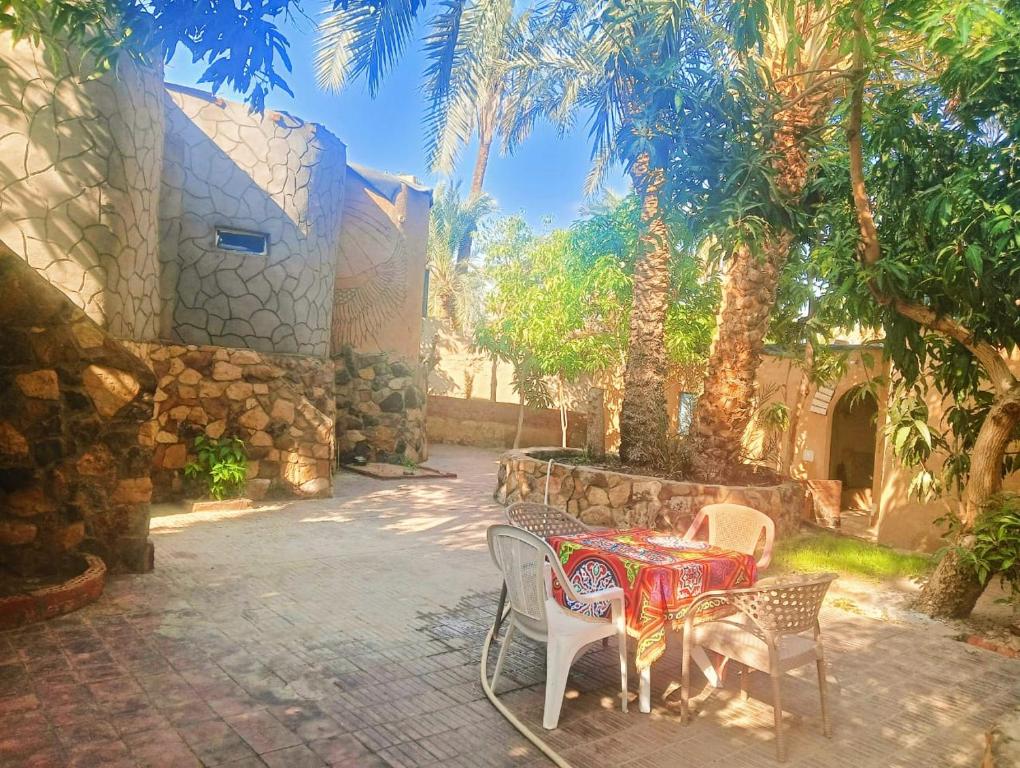 BawatiNew Oasis的一个带桌椅和棕榈树的庭院