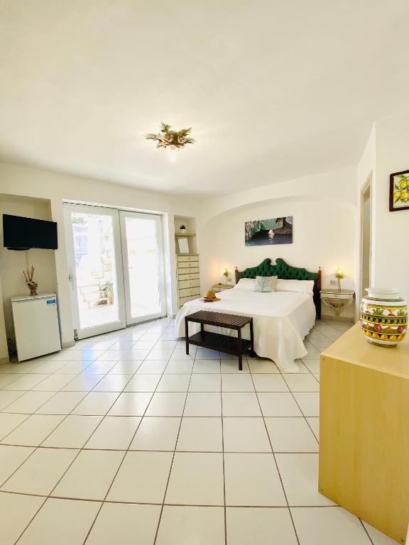 阿纳卡普里Casa Pippo 2的卧室设有床铺,铺有白色的宽大地板