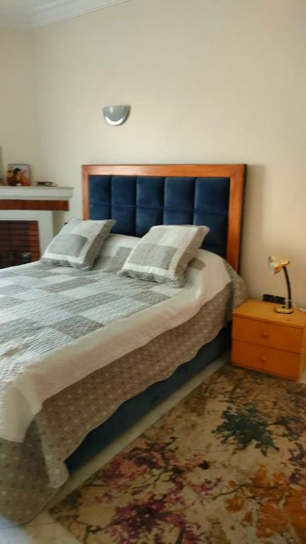 乌季达Logement calme très proche du centre的一间卧室配有一张大床和蓝色床头板