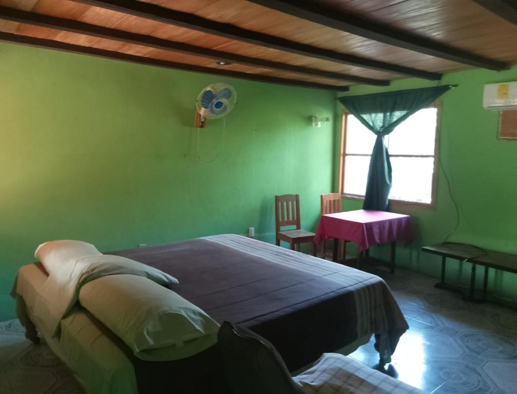 Tuxtla ChicoHotel El Dorado的一间卧室配有一张床、一张桌子和一个窗户。