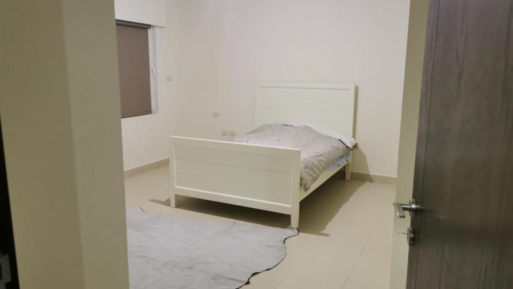 Al Andulcia Airport Road Complex مجمع الاندلسية طريق المطار的一间白色客房内的床铺卧室