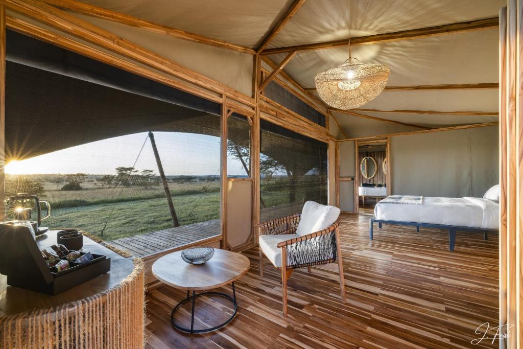 塞伦盖蒂Anantya Serengeti的帐篷内一间卧室,配有一张床和一张沙发