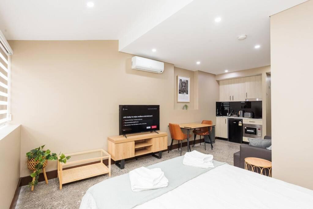 悉尼NEW! Ideal 1BR Unit in the Hot Spot of Surry Hills的一间卧室设有一张床和一间客厅。
