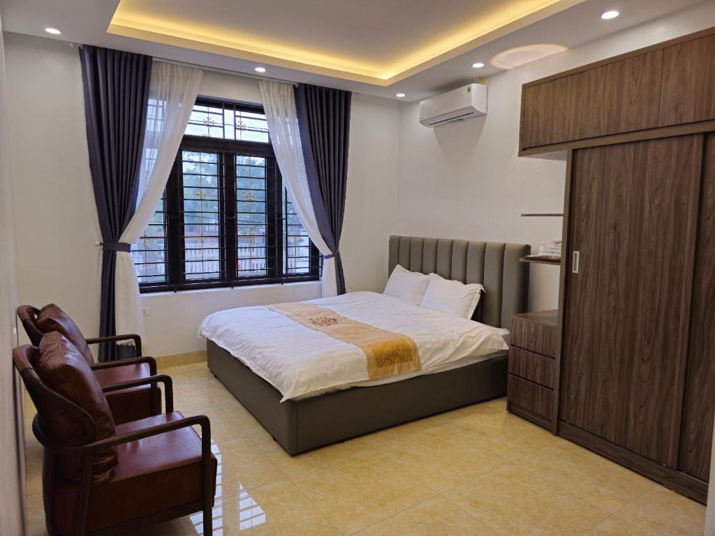 Làng Trang4L HOTEL KIM BÔI的卧室配有床、椅子和窗户。