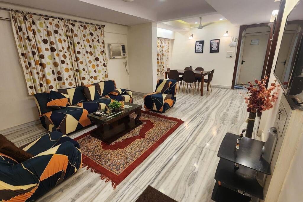 孟买Home sweet home 3BHK的带沙发的客厅和用餐室