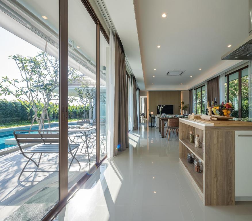 华欣Relaxing Luxury 3-Bed Private Villa的一间厨房和带滑动玻璃门的用餐室