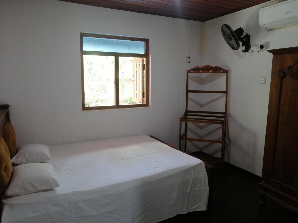 马特莱Geeth Lanka River Resort的卧室配有白色的床和窗户。