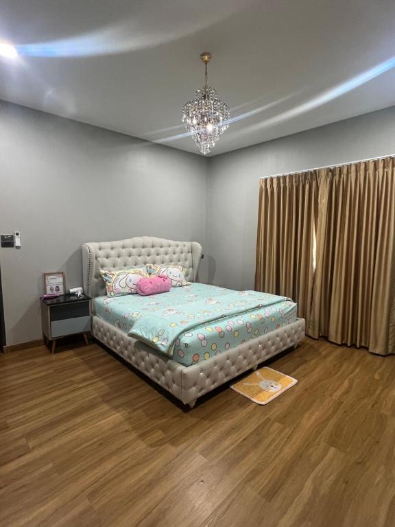 合艾Pani House ( Hatyai 3 )的一间卧室配有一张床和一个吊灯