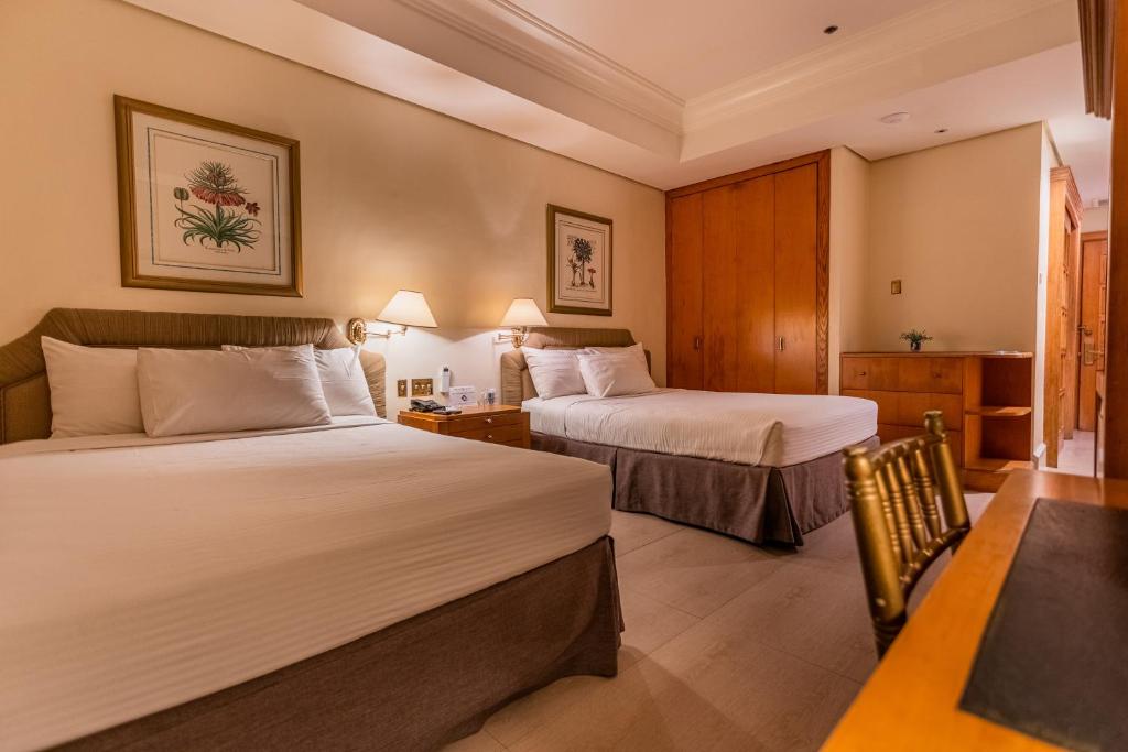 奥隆阿波The Subic Bay Yacht Club, Inc.的酒店客房设有两张床和一张桌子。