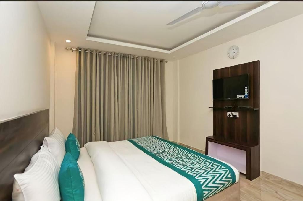 新德里Hotel Global Radiance Stay Near Delhi Airport的酒店客房,配有床和电视