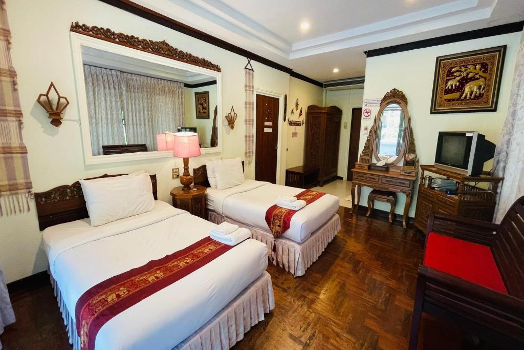 北碧Baan Rim Kwai Paerimnam Resort的酒店客房设有两张床和电视。