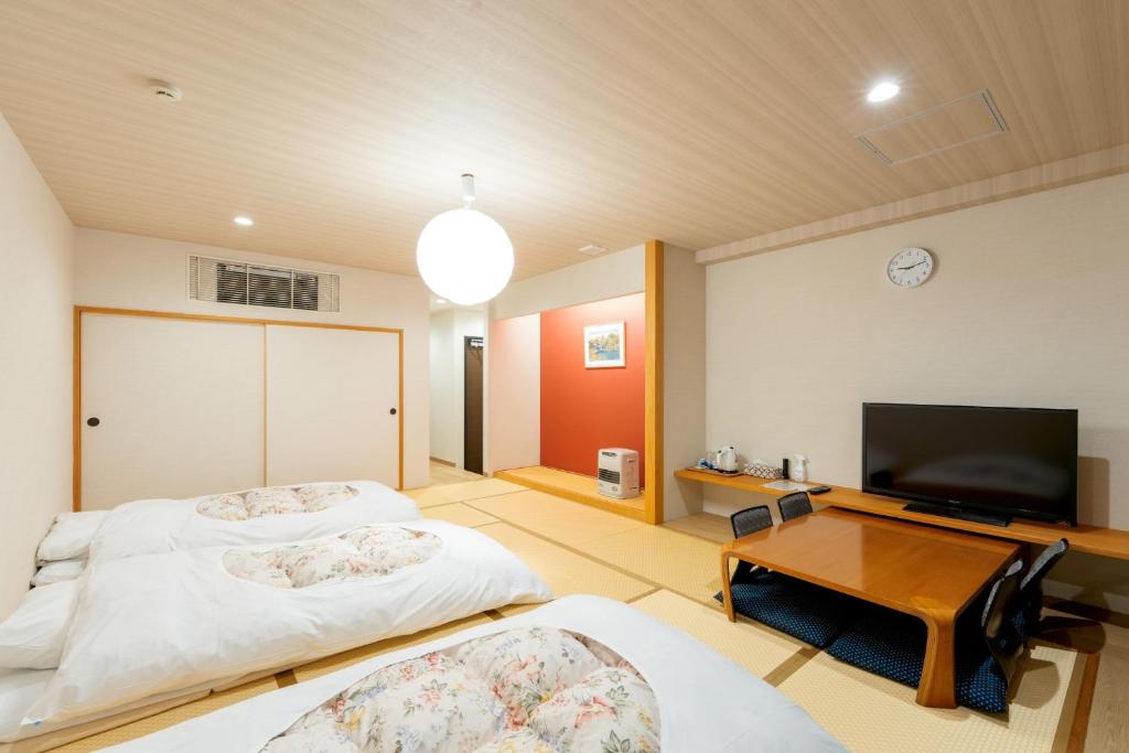 SukawaFuji Shoei Hall - Vacation STAY 09374v的配有平面电视的客房内的两张床