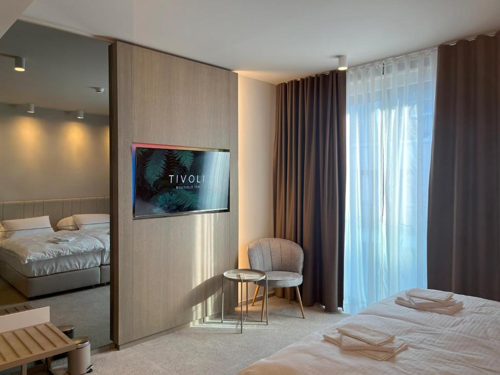 卢布尔雅那Tivoli Boutique Inn的一间酒店客房,配有一张床和一台墙上的电视