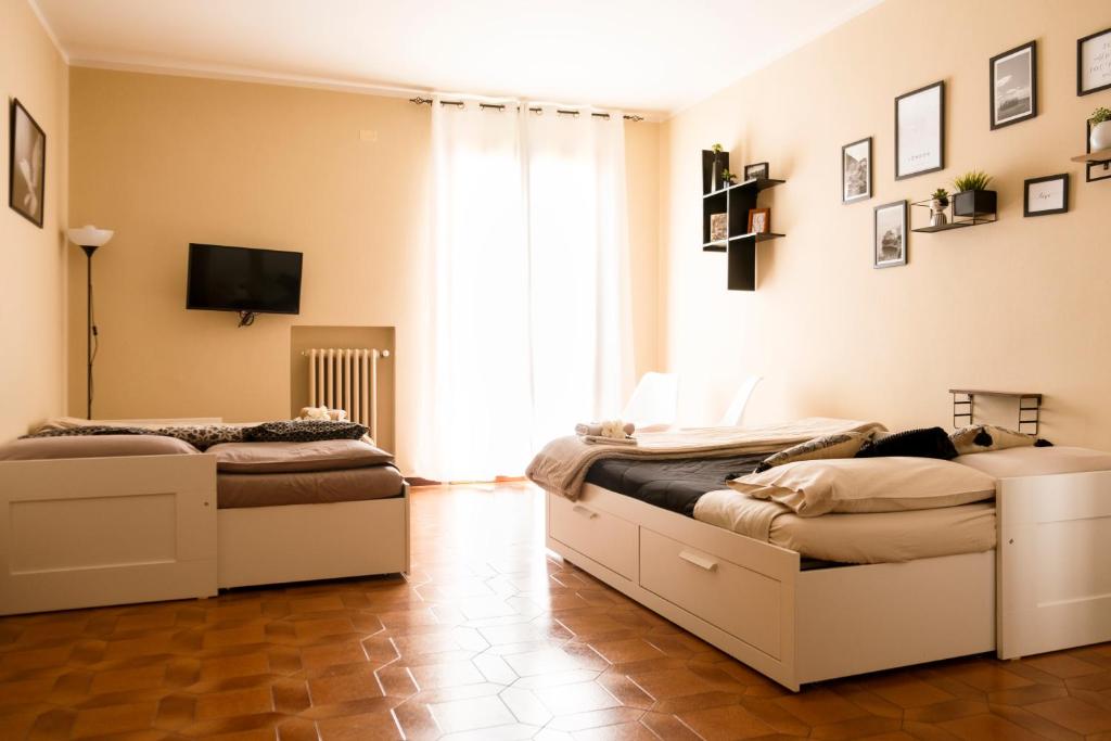 富切基奥Le Case di Sonia DEL CORSO CIV 25 Fucecchio的配有两张床铺的客房,墙上配有电视