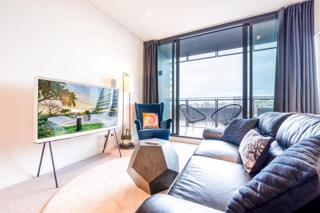 悉尼Contemporary 2-Bed Apartment Minutes to City的带沙发和大窗户的客厅