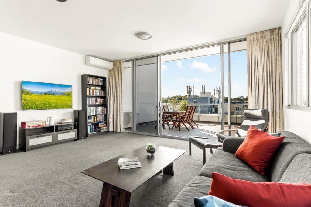悉尼Spacious 2-Bed with Two Balconies with City Views的客厅配有沙发和桌子