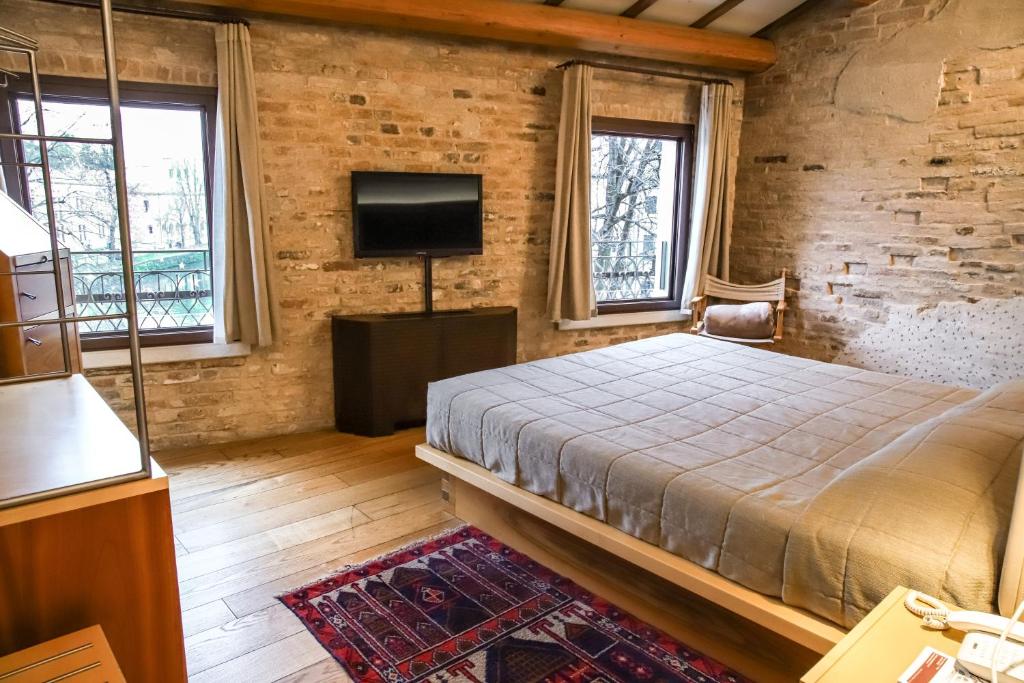 特雷维索罗坎达庞特丹住宿加早餐旅馆的一间卧室设有一张床、一台电视和窗户。