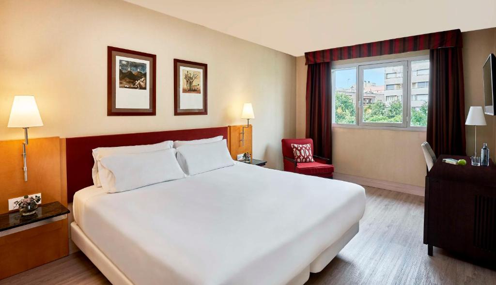 雷乌斯NH雷乌斯城市酒店的一间设有大床和窗户的酒店客房