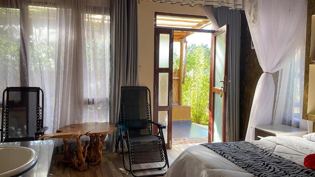 埃尔多雷特Tiret Riverside Resort and Retreat的卧室配有一张床和一张桌子及椅子