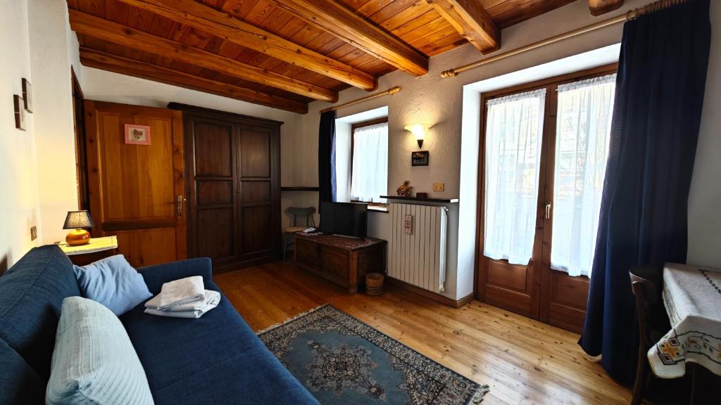 普拉吉拉托Hostdomus - La Posta apartment的客厅设有蓝色的沙发和木制天花板。