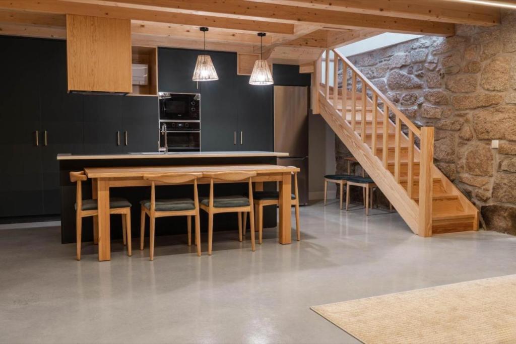 维拉·雷阿尔Casa Da Eira的厨房设有木桌和楼梯。