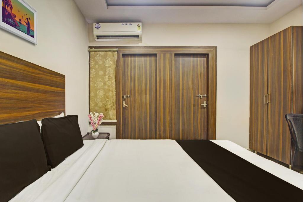海得拉巴OYO Hotel Srujana Stay Inn Opp Public Gardens Nampally的一间卧室设有一张床和木门