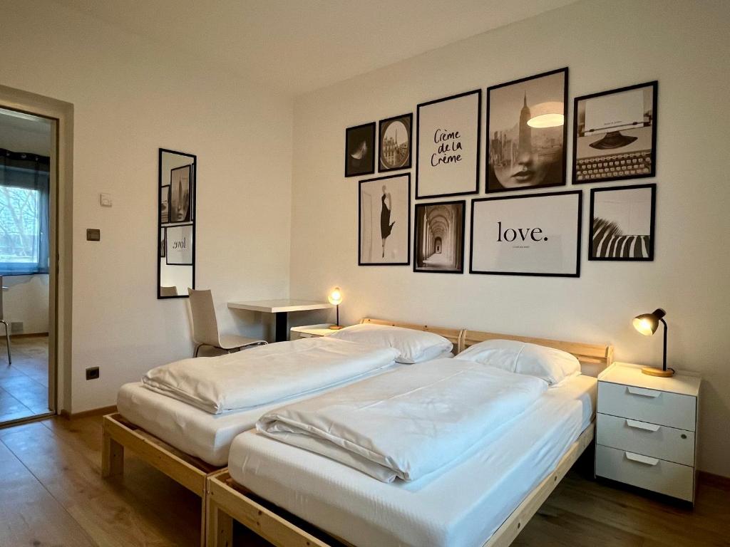 格拉茨sHome CityHouse Graz - Self-Check-in的墙上有两张照片的房间的床铺