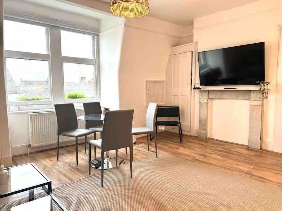伦敦One Bed Apartment- Muswell Hill的客厅配有桌椅和平面电视。